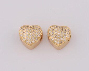 May include: Two gold heart-shaped charms with clear cubic zirconia stones.