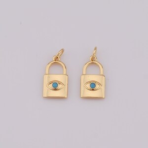 Op de afbeelding: Twee gouden slotbedels met een blauw boze oogontwerp. De bedels zijn perfect om een ​​toets van stijl toe te voegen aan kettingen, armbanden of sleutelhangers.