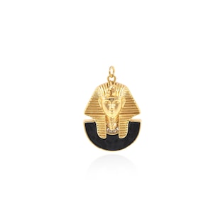 May include: Gold pendant featuring a detailed depiction of an Egyptian pharaoh's head with a black enamel background.