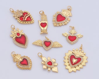 May include: A collection of gold-colored pendants with red heart-shaped centers. The pendants feature various designs, including wings, crowns, and floral elements, and are embellished with small, clear crystals. Each pendant has a loop for attaching to a chain or other jewelry.