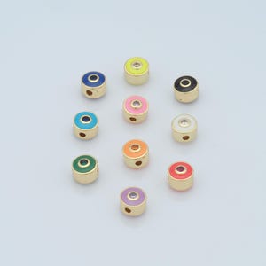 May include: Assortment of ten round, gold-toned beads with enamel and a clear rhinestone in the center. The beads are in various colors, including yellow, blue, black, pink, white, turquoise, green, orange, red, and purple.
