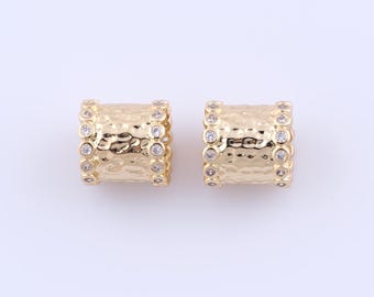 May include: A pair of gold hoop earrings with a hammered texture and clear crystal accents.