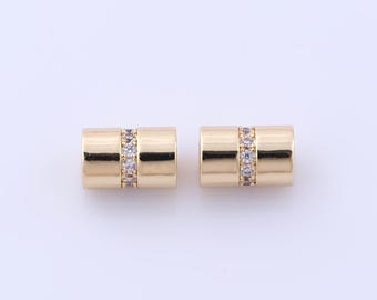 May include: Two gold-toned cylindrical earrings with a row of clear cubic zirconia stones around the center of each earring.