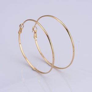 May include: A pair of gold hoop earrings. The earrings are large and circular, with a simple design.