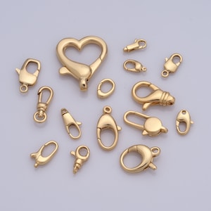 Puede incluir: Una colección de cierres y conectores de metal dorado para la elaboración de joyas. Los cierres vienen en una variedad de formas, incluyendo corazón, ovalado y de langosta.
