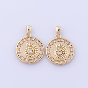 May include: Two gold-tone pendants with a spiral design and clear rhinestones. Each pendant is round and has a loop at the top for attaching to a chain.