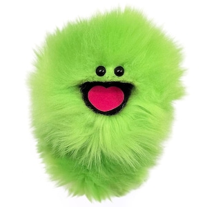 May include: A round, lime green plush toy covered in long, shaggy faux fur. The creature features two small, round, black plastic eyes positioned above a wide, open mouth with a bright pink, heart-shaped tongue visible inside the dark interior.