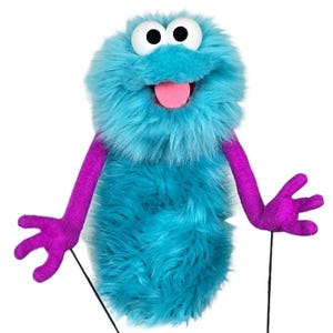 May include: A fuzzy turquoise hand puppet featuring a round head with large white eyes, black pupils, and a pink tongue visible in an open mouth. The puppet has long purple arms with four-fingered hands and two thin black control rods attached.