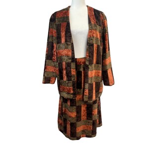 May include: A brown, green and orange patterned velvet jacket and skirt set. The jacket has a long, open front and the skirt is knee-length.