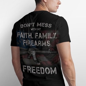 May include: Black t-shirt with a distressed American flag design and the text "Don't mess with my faith, family, firearms or freedom".