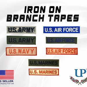 May include: Iron-on branch tapes for military uniforms. The tapes feature the words "U.S. Army", "U.S. Air Force", "U.S. Navy", and "U.S. Marines" in various colors and camouflage patterns.
