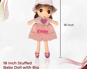 Può includere: Una bambola di peluche rosa e bianca di 45,7 cm con occhi grandi, un cuore rosa sulla sua maglietta e un cappello a righe rosa e bianco. La bambola indossa un vestito rosa con il nome "Emma" ricamato.