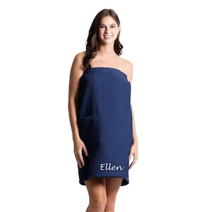 May include: A navy blue waffle weave spa wrap with a pocket and the name "Ellen" embroidered on the bottom.