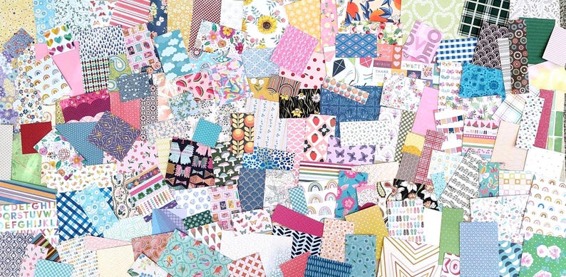 May include: A collage of colorful patterned paper scraps in various shapes and sizes. Designs include florals, polka dots, stripes, and geometric patterns in shades of pink, blue, yellow, and green. Ideal for scrapbooking and crafting projects.