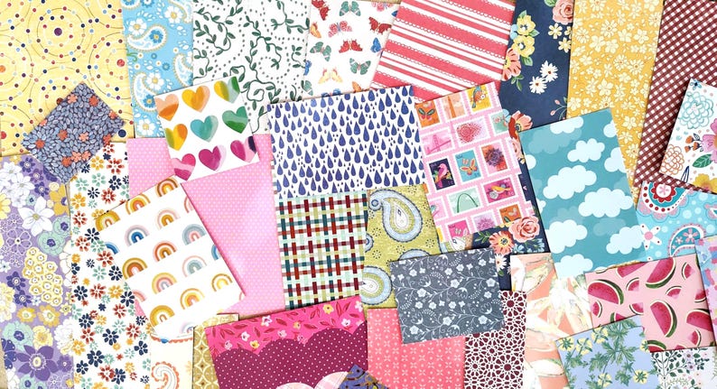 May include: A collection of colorful patterned paper sheets. Designs include hearts, rainbows, clouds, floral, and geometric patterns. The color palette is diverse, featuring pink, blue, yellow, and red hues. Ideal for scrapbooking, card making, and other paper crafts.