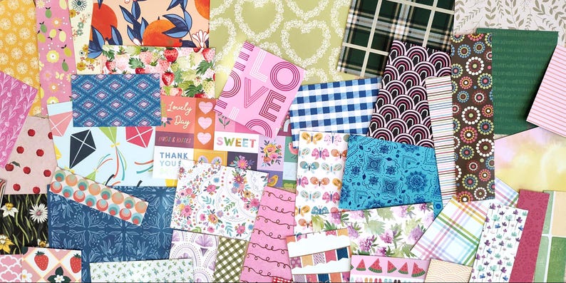 May include: A collection of patterned paper sheets in various designs and colors. Includes floral, geometric, and text-based patterns. The color palette features pinks, blues, greens, and oranges. Some sheets have the word "LOVE" printed on them.