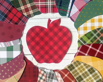 May include: A red and white plaid apple shape surrounded by various plaid patterns in red, green, yellow, and brown.