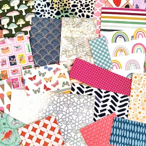 May include: A collection of patterned paper sheets in various colors and designs. The sheets feature patterns such as butterflies, bows, mushrooms, and floral motifs. The color palette includes pink, blue, green, and yellow.