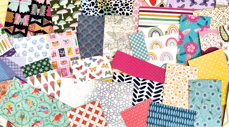 May include: A collection of patterned paper sheets in various colors and designs. The sheets feature patterns such as butterflies, bows, mushrooms, and floral motifs. The color palette includes pink, blue, green, and yellow.