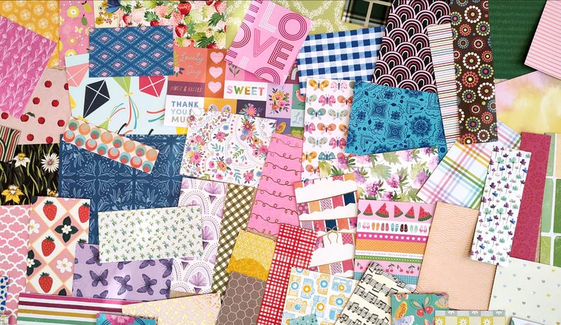 May include: A collage of patterned paper sheets in various colors and designs. Pink, blue, and green are prominent, with floral, geometric, and text-based patterns. Some sheets have text that reads "LOVE" and "SWEET".