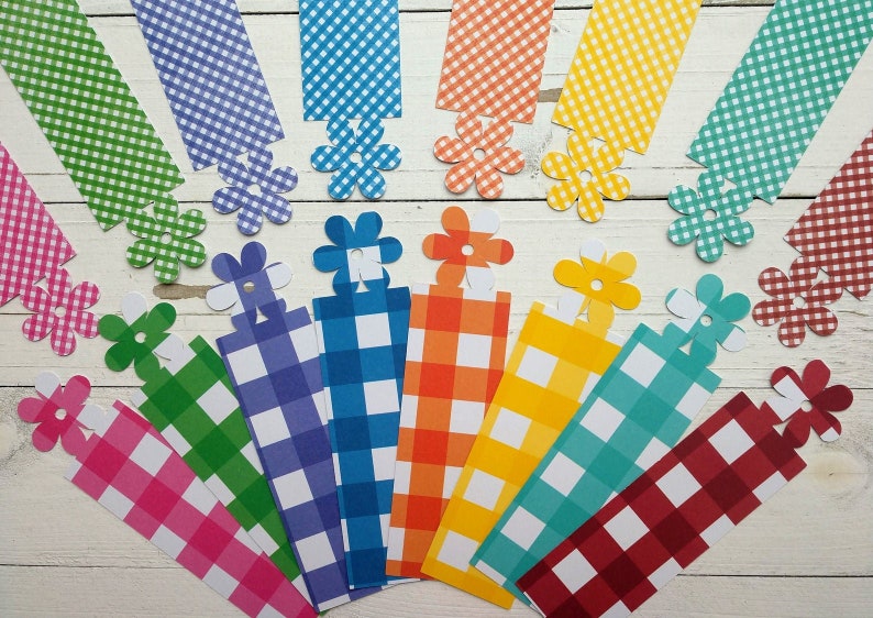May include: A set of 10 colourful gingham fabric bookmarks with a white flower design. Each bookmark is approximately 15 cm long and features a different colour gingham pattern.