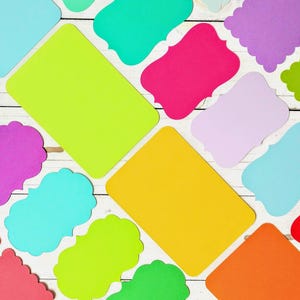 May include: A collection of assorted paper die-cut shapes in various colors including lime green, hot pink, yellow, orange, red, purple, light blue, and lavender. The shapes feature rectangular, scalloped, and ornate decorative edges.