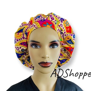 May include: A colorful patterned surgical cap with a paisley design in shades of yellow, red, purple, and blue. The cap is made of a soft, comfortable fabric and is designed to be worn by medical professionals.
