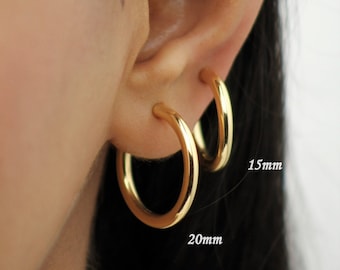 May include: Two gold hoop earrings, one 20mm and one 15mm in diameter.