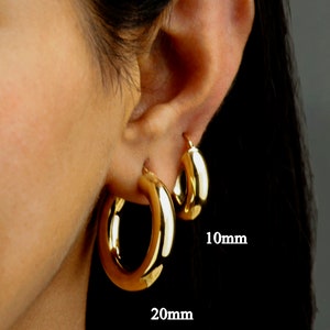 May include: A close-up of a person's ear wearing three gold hoop earrings. The earrings are 10mm, 20mm, and 30mm in diameter. The text "Serena Sparkles" is visible at the bottom of the image.