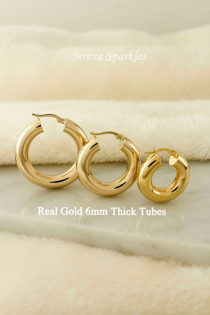 May include: Three gold hoop earrings of different sizes. The earrings are 6mm thick and made of real gold.  "Real Gold 6mm Thick Tubes" is written below the earrings.