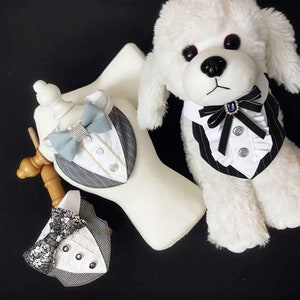 May include: Dog tuxedo vests in black and white pinstripe, grey and white checkered, and grey pinstripe designs. Each vest features a bow tie and button details. A white stuffed dog wears a black and white pinstripe vest with a black bow tie.