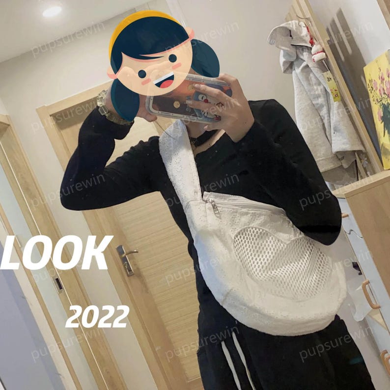 May include: A white mesh bag with a heart-shaped opening. The bag is worn as a crossbody bag and has a zipper closure. The bag is made of a soft, textured fabric.