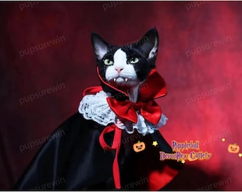 Puede incluir: Un gato Devon Rex blanco y negro con un disfraz de vampiro negro y rojo con un collar de encaje blanco y una pajarita roja. El gato tiene colmillos y mira a la cámara. El fondo es una pared roja con el texto "Rippledoll Devon Rex Cattety" en blanco.