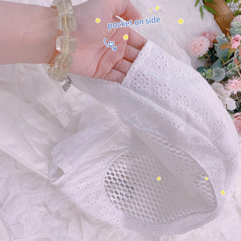 May include: White cotton dress with a mesh panel and a pocket on the side. The dress has a delicate embroidered pattern.