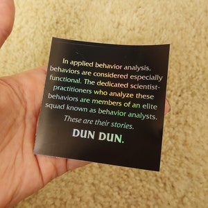 May include: A black sticker with white text that reads "In applied behavior analysis, behaviors are considered especially functional. The dedicated scientist-practitioners who analyze these behaviors are members of an elite squad known as behavior analysts. These are their stories. DUN DUN."