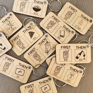 May include: A set of ten wooden keychains with the words "First" and "Then" printed on them. Each keychain has a different image on each side, such as a clipboard, pizza, ice cream, and a glass of wine.