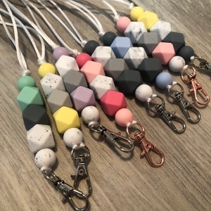 May include: A set of colorful silicone bead necklaces with a variety of colors and patterns, including marble, solid, and speckled. Each necklace has a silver lobster clasp.