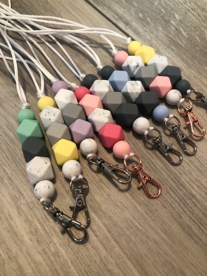 May include: A set of colorful silicone bead necklaces with a variety of colors and patterns, including marble, solid, and speckled. Each necklace has a silver lobster clasp.