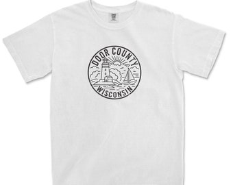 May include: White t-shirt with a black and white graphic of a lighthouse, a sailboat, and the text "DOOR COUNTY WISCONSIN".
