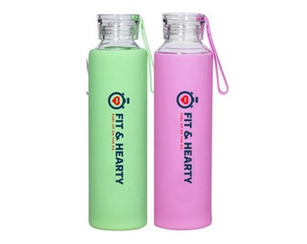 May include: Two glass water bottles with silicone sleeves. The bottle on the left has a green sleeve and the bottle on the right has a pink sleeve. Both bottles have a logo that says "Fit & Hearty Fuel Up On The Go".