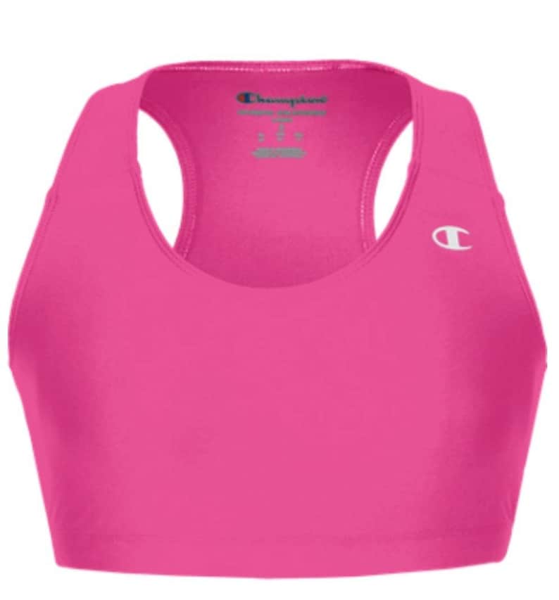 May include: Pink sports bra with a racerback design and a Champion logo on the front. The bra has a scoop neck and a wide band.