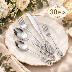 May include: A 30-piece silver-toned stainless steel flatware set featuring a dinner fork, a dinner knife, a dinner spoon, and a smaller spoon. Each piece has an ornate, embossed handle design with intricate floral and scrollwork detailing.