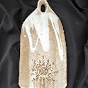 Rustic handmade stoneware charcuterie or cheese board with sun detail