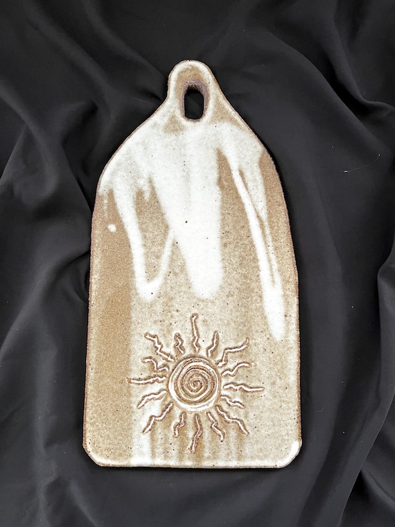 Rustic handmade stoneware charcuterie or cheese board with sun detail