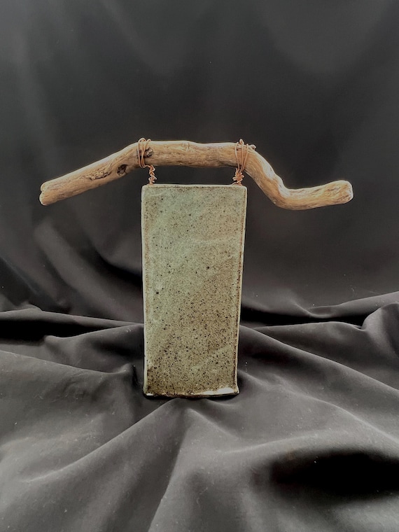 Handmade stoneware vase with driftwood