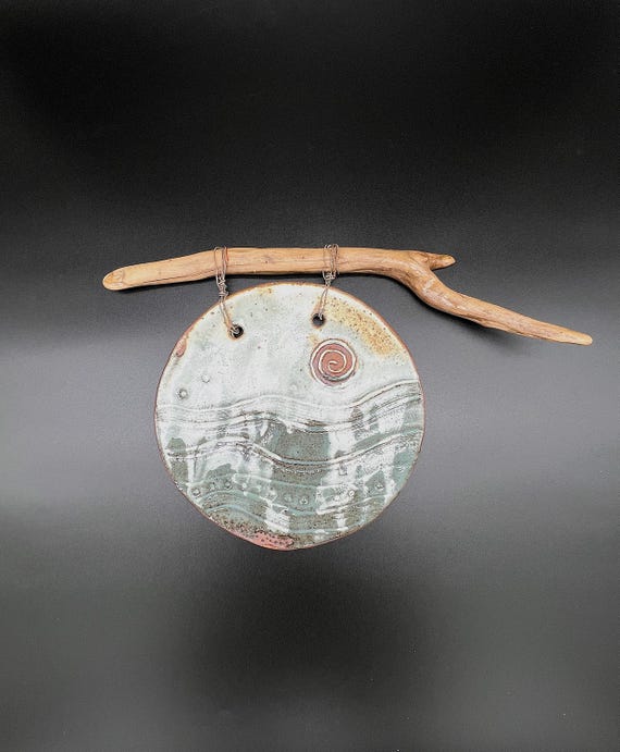 Handmade rustic pottery wall hanging with driftwood