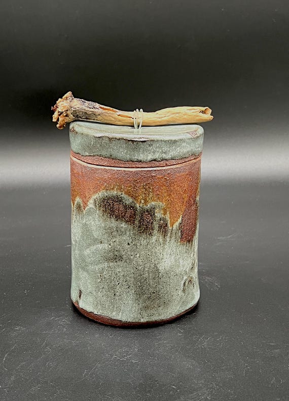 Tall handmade rustic pottery stoneware box with driftwood accent. Deep celadon glaze with exposed clay body.
