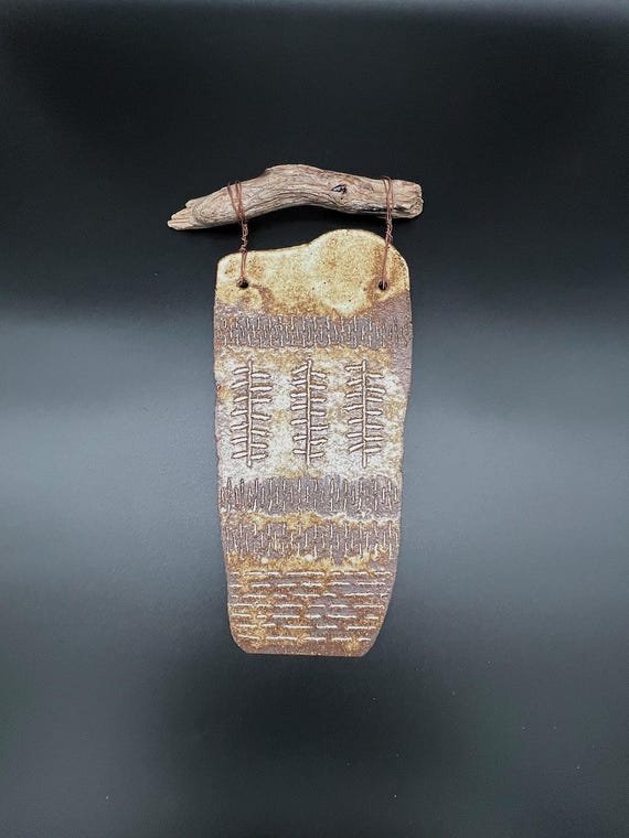 Handmade rustic pottery wall hanging with driftwood
