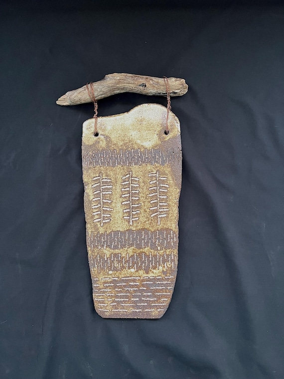 Handmade rustic pottery wall hanging with driftwood