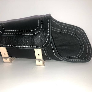 Pu&ograve; includere: Sella da moto in pelle nera con cuciture bianche e fibbie color crema.